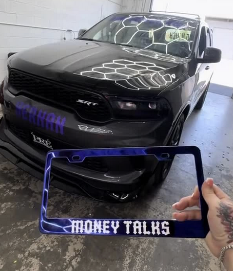 Money Talks license plate frame in front of a black SUV